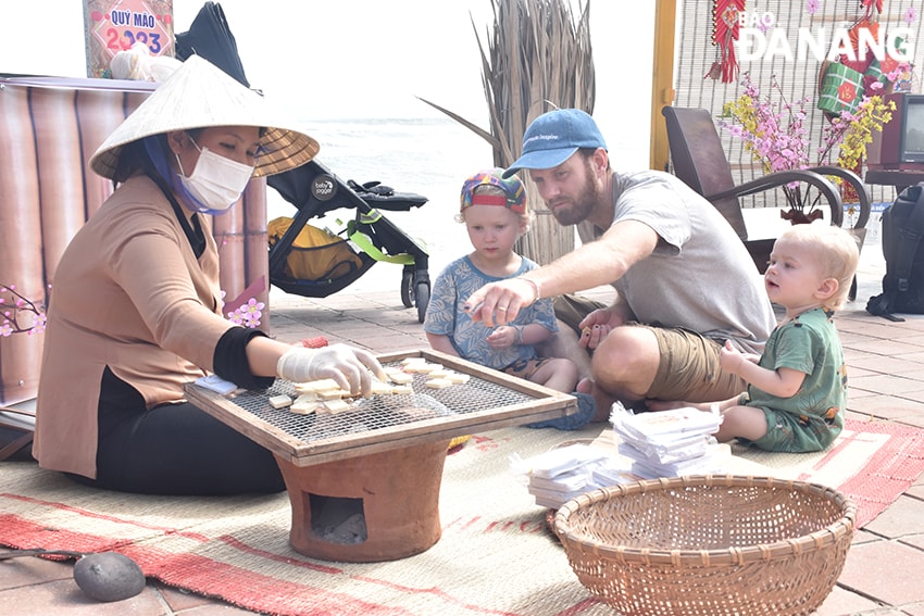 Anh Erik Vismer, quốc tịch Thụy Điển đã sinh sống tại Đà Nẵng 4 năm, anh cùng các con hào hứng thưởng thức món bánh in, mứt dừa. Ảnh: THU HÀ