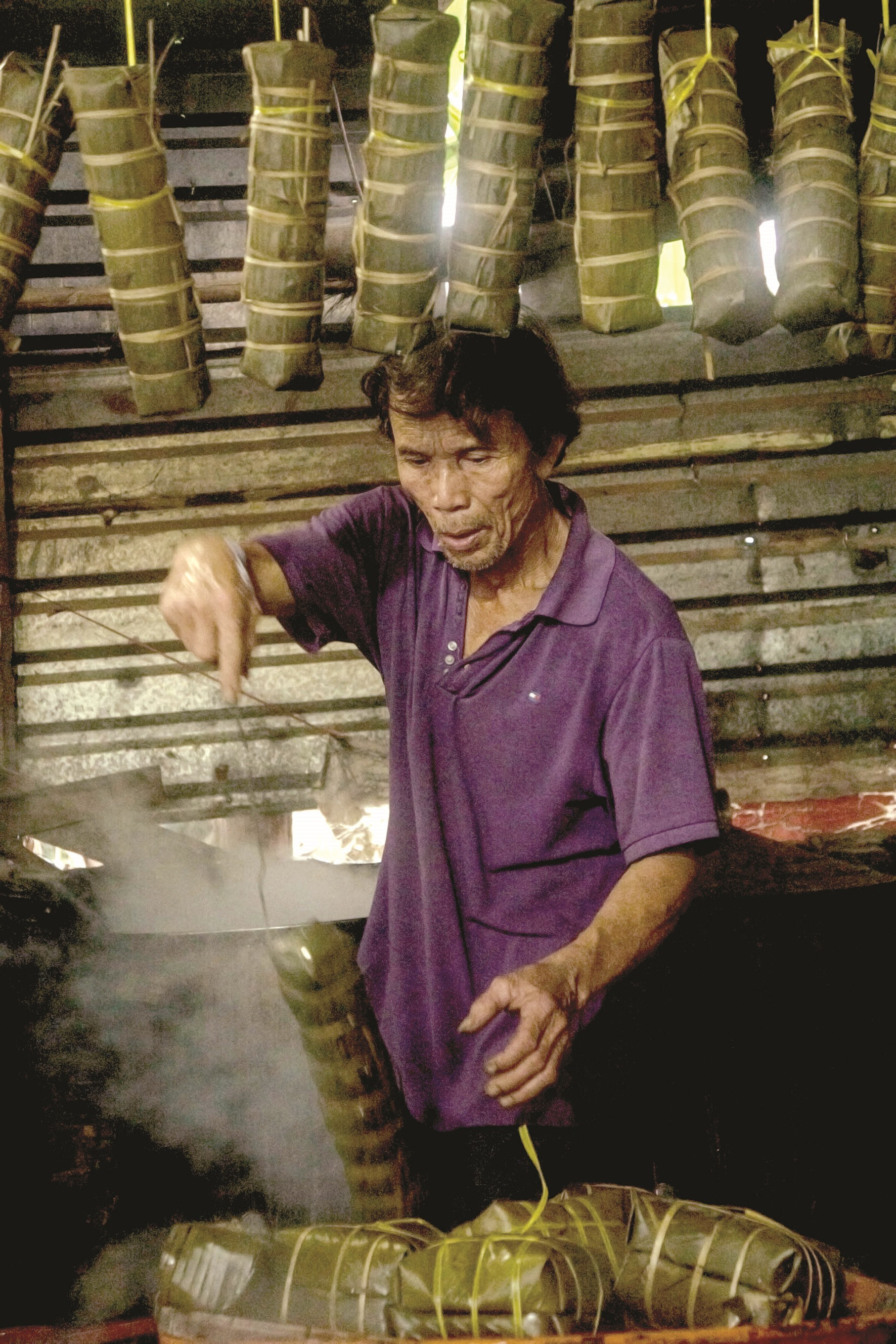 Ông Phan Đình Khé (khối phố Hương Sơn) vớt bánh đã chín ra để nguội trước khi bán.