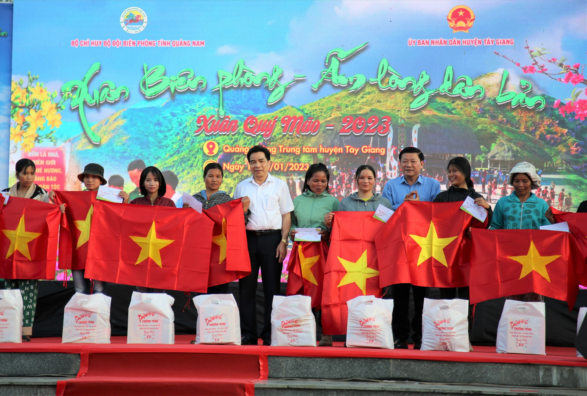 Đại diện lãnh đạo tỉnh trao tặng cờ Tổ quốc cho người dân trong chương trình “Xuân biên phòng - Ấm lòng dân bản” được tổ chức tại Tây Giang. Ảnh: A.N