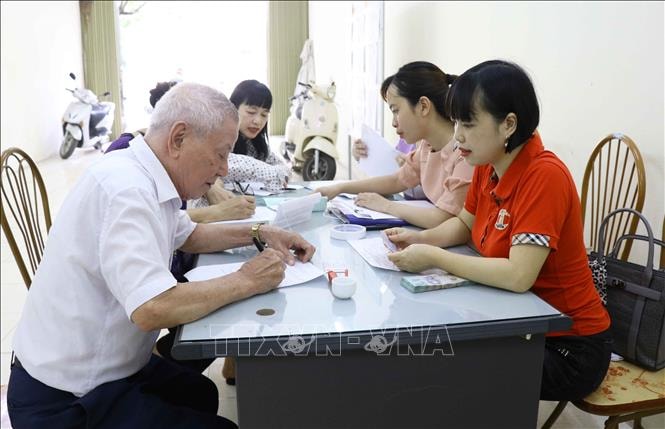 Người dân nhận tiền từ gói an sinh xã hội của Chính phủ. Ảnh: Báo Tin tức