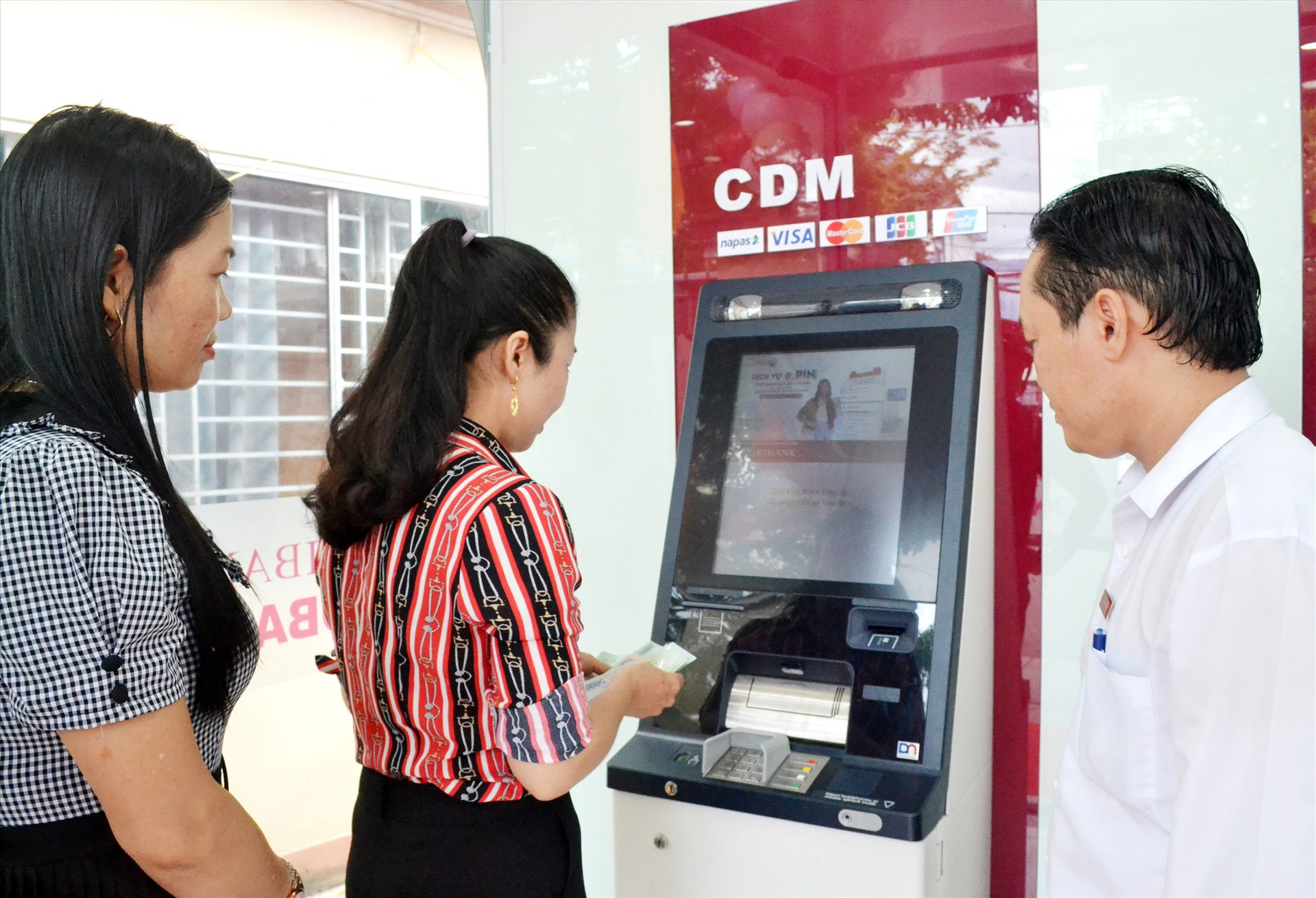 Người dân giao dịch tiện lợi nhờ Agribank Quảng Nam ứng dụng máy rút tiền, chuyển tiền tự động. Ảnh: NGUYỄN QUANG