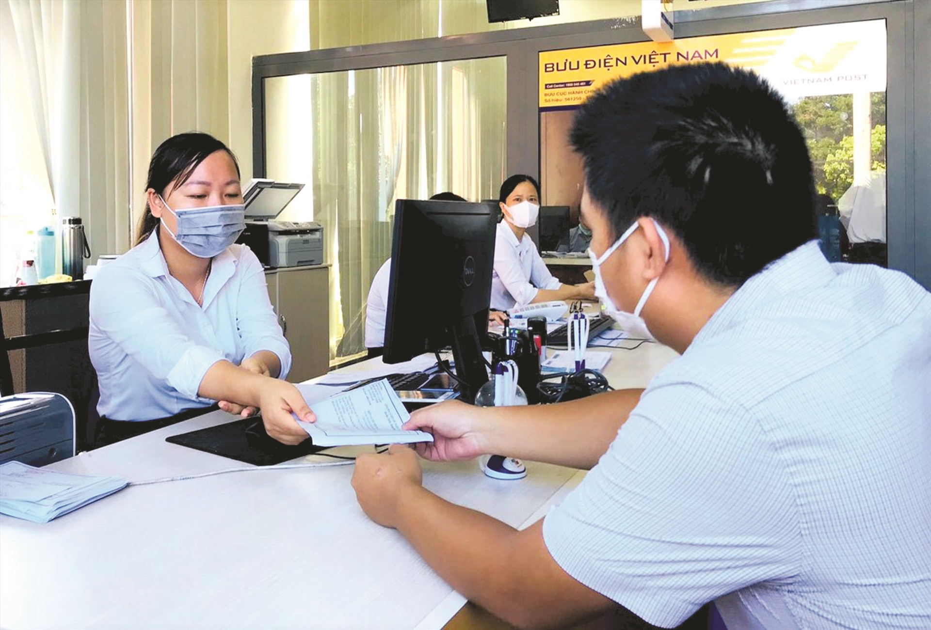 Nhân viên Bưu điện Quảng Nam thực hiện thu hộ lệ phí giải quyết TTHC tại Trung tâm Phục vụ hành chính công tỉnh. Ảnh: V.A