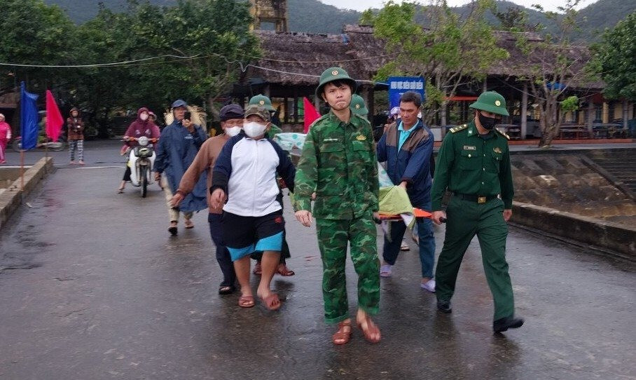 Cán bộ, Chiến sĩ Đồn Biên phòng Cù Lao Chàm phối hợp người dân đưa 2 người dân cấp cứu. Ảnh: HỒNG ANH