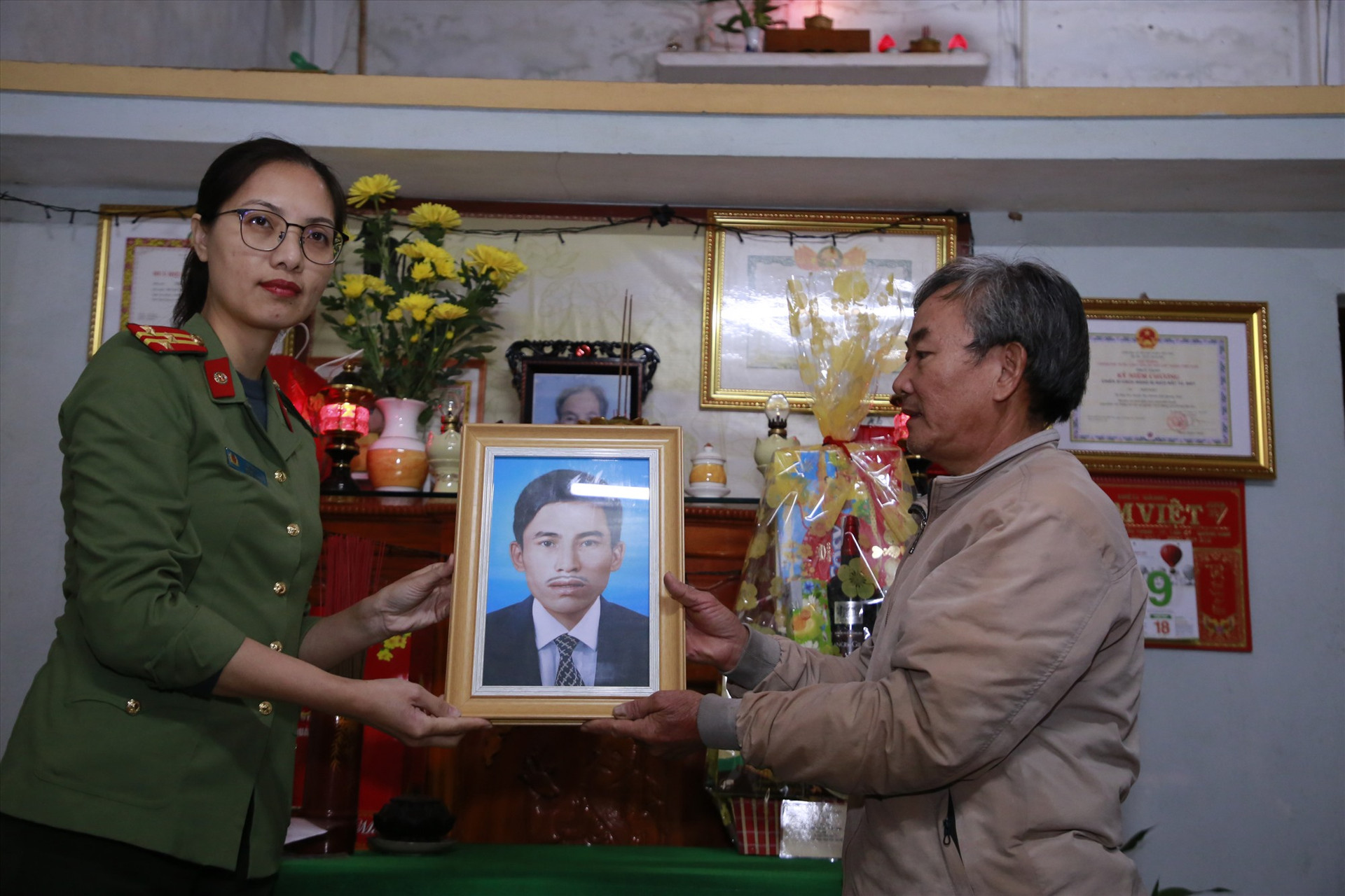 Thượng tá Lê Thị Lý trao tặng di ảnh liệt sĩ Ngô Kiệt cho con trai liệt sĩ. Ảnh: T.C