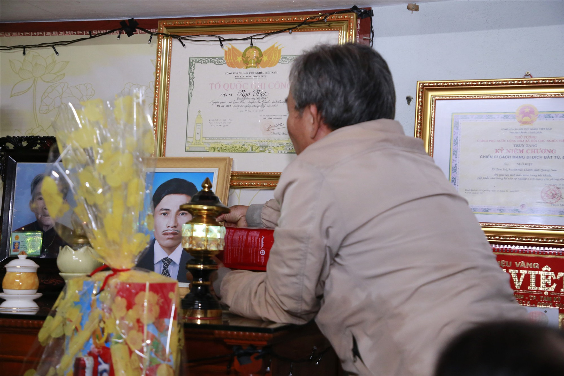 Ông Ngô Thanh Cường trang trọng đặt di ảnh của cha lên bàn thờ, sau 58 năm gia đình liệt sĩ không có di ảnh. Ảnh: T.C