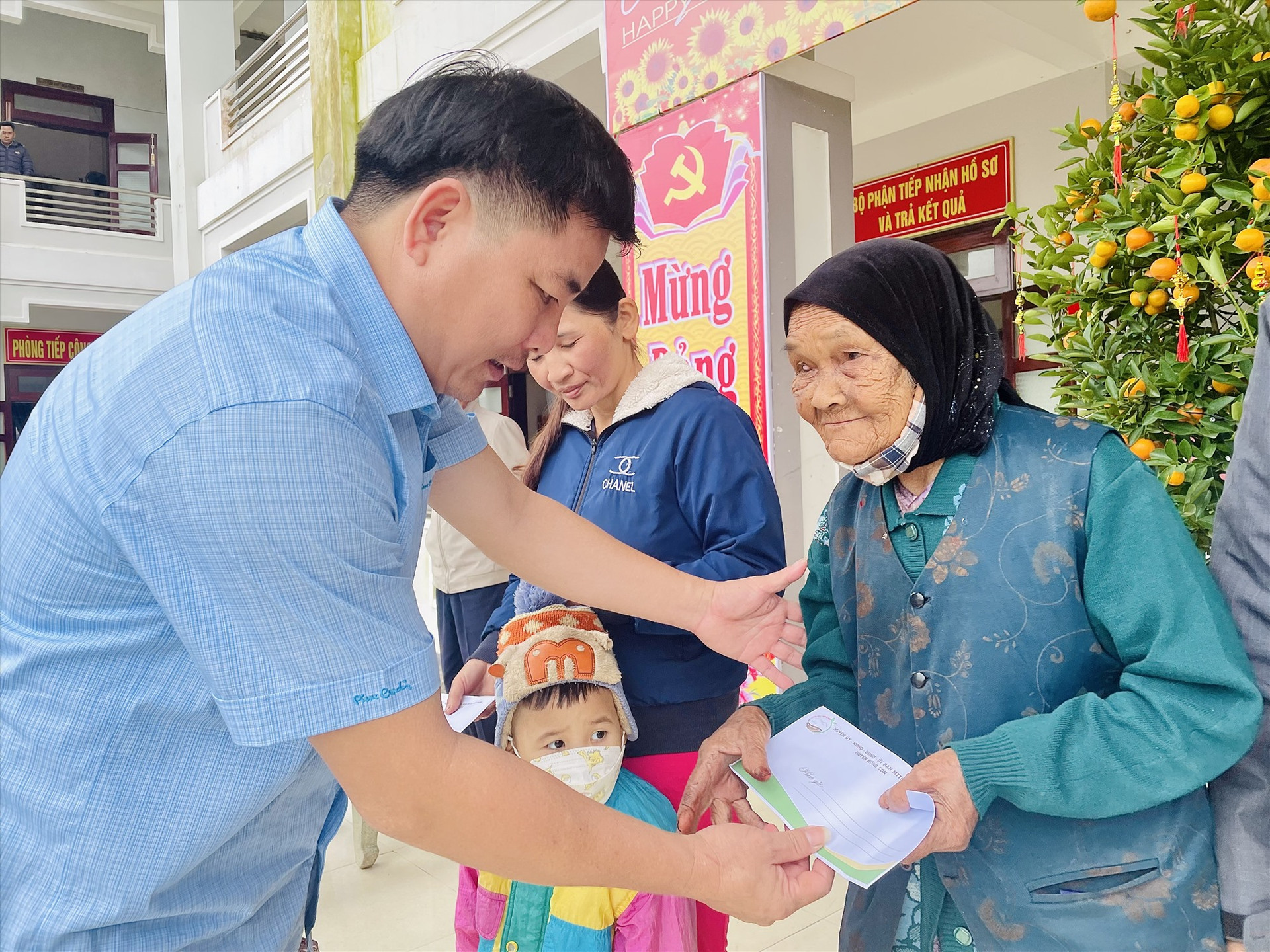 Chủ tịch UBND huyện Nông Sơn - Nguyễn Văn Hòa trao quà tết cho các hộ khó khăn xã Ninh Phước. Ảnh: TÂM THÔNG