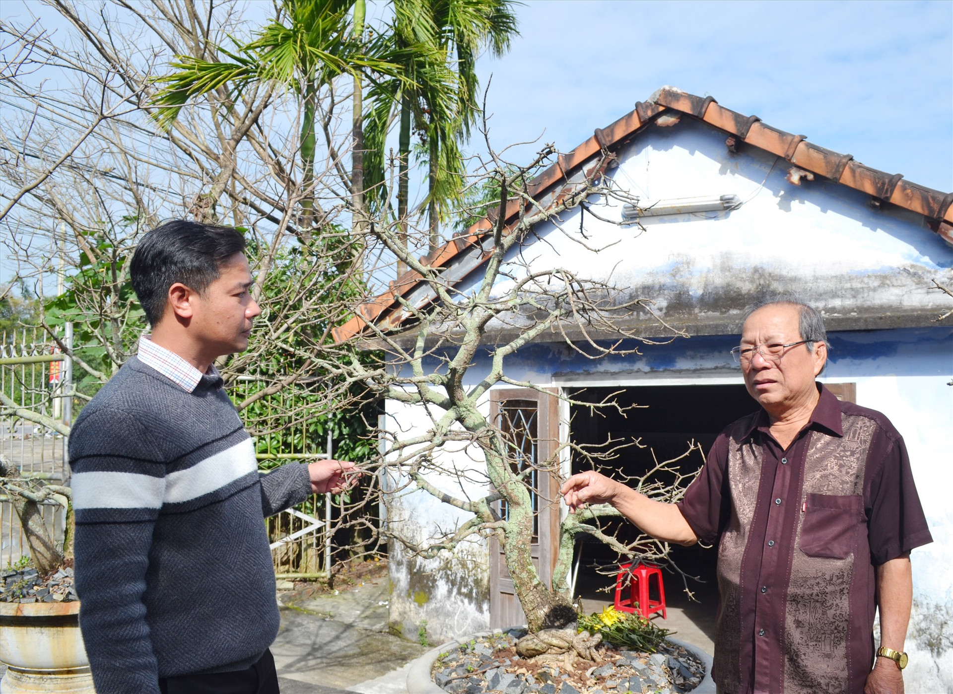 Ông Nguyễn Ngọc Tân (phải) - Bí thư chi bộ khu phố 9 (Hà Lam) nói chuyện với ông Hoàng Công Tài - cán bộ Văn phòng Đảng ủy thị trấn Hà Lam về công tác xây dựng Đảng trên địa bàn. Ảnh: VIỆT NGUYỄN