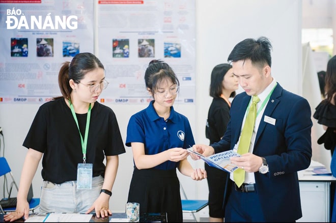 Nguyễn Tỉnh (giữa) chia sẻ thông tin về tái chế rác thải cho khách hàng Evergreen Labs tại một hội thảo. Ảnh: T.Y