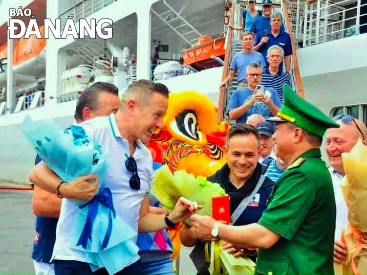 Trung tá Đoàn Văn Tỉnh, Chỉ Huy trưởng Biên phòng Cửa khẩu cảng Đà Nẵng (bên phải) đón du khách khi tàu du lịch Sliver Spirit cập cảng Tiên Sa. Ảnh: B.V
