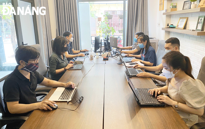 Một trong những nhiệm vụ trọng tâm chuyển đổi số năm 2023 của thành phố là triển khai hiệu quả kế hoạch phát triển doanh nghiệp công nghệ số. TRONG ẢNH: Nhân viên Công ty CP Zinwork (quận Thanh Khê) đang làm việc tại văn phòng. Ảnh: M.Q
