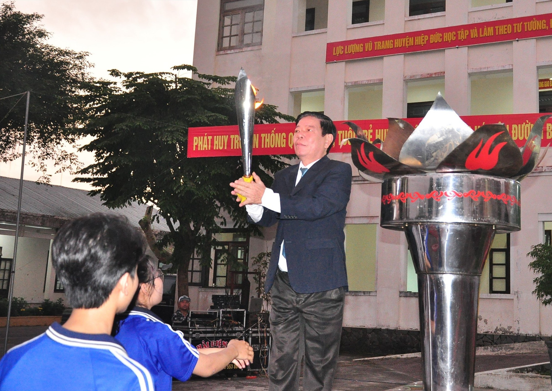 Bí thư Huyện ủy Hiệp Đức Nguyễn Văn Tỉnh thực hiện nghi thức thắp lửa truyền thống tại lễ giao nhận quân. Ảnh: VINH ANH