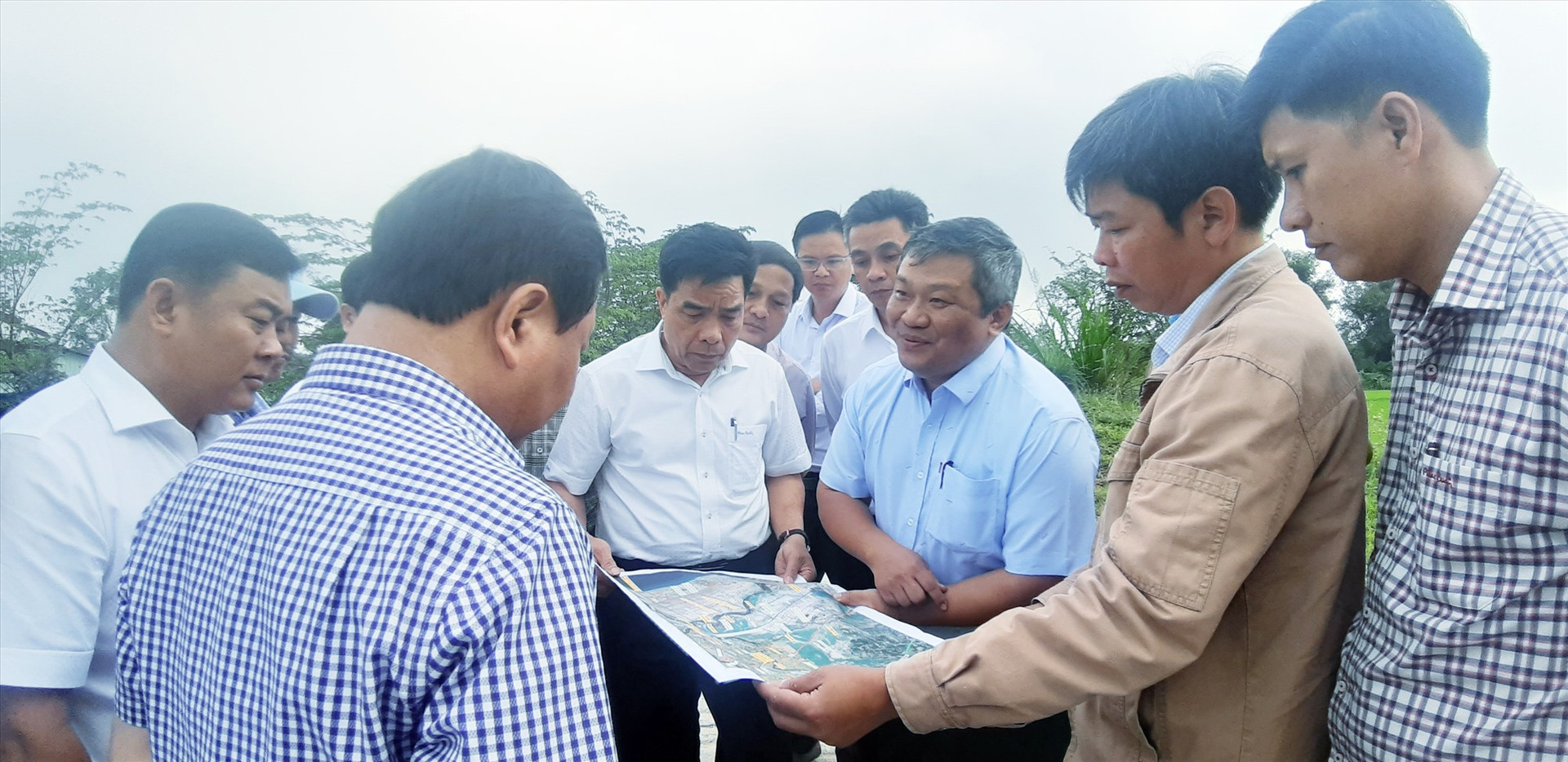 Đoàn công tác của tỉnh nghe báo cáo tiến độ xây dựng công trình cầu Trà Đình (xã Quế Phú, Quế Sơn).   Ảnh: VĂN SỰ