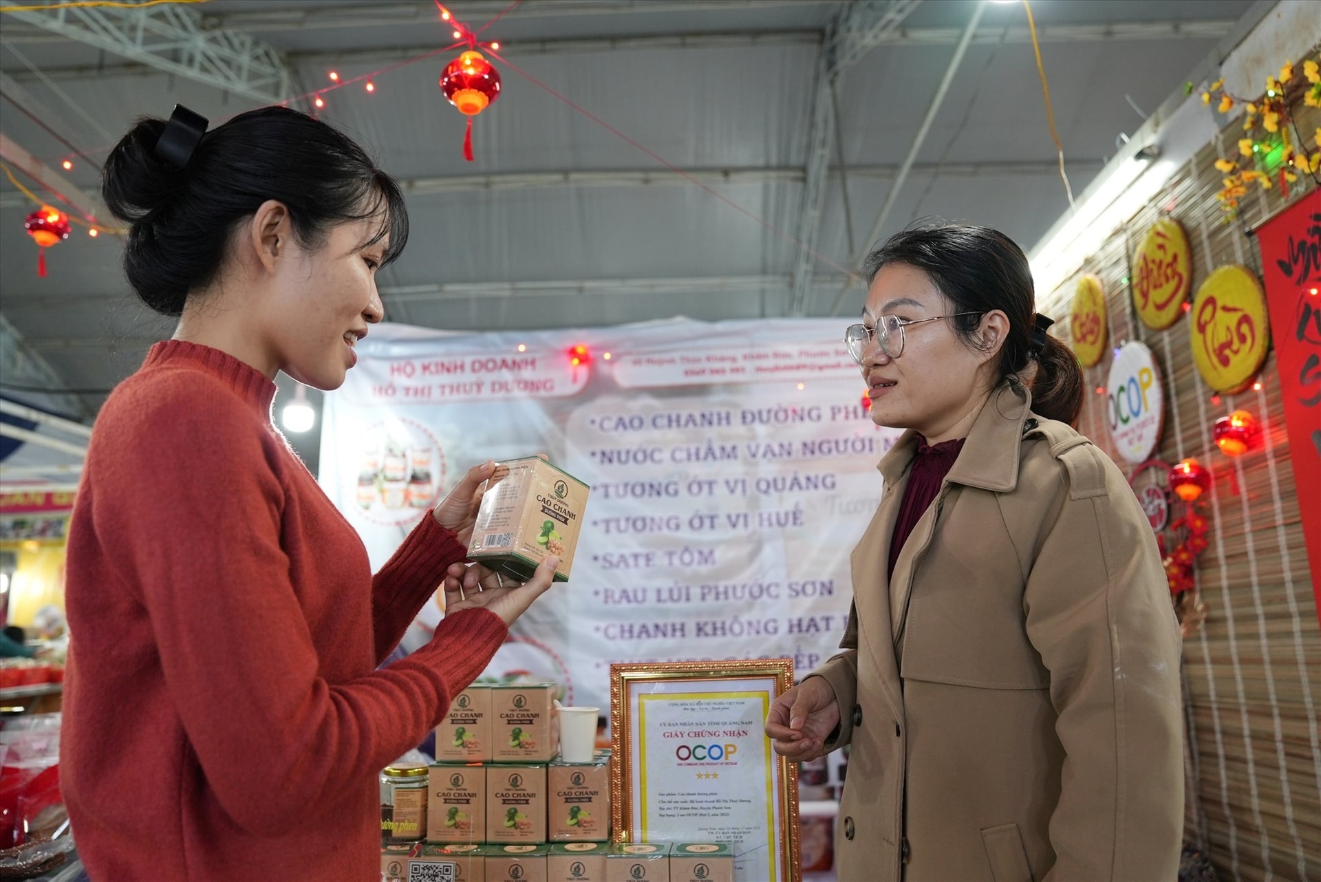 Chị Hồ Thị Thùy Linh (bên phải) giới thiệu sản phẩm cao chanh đường phèn Thùy Dương cho khách hàng. Ảnh: L.Q