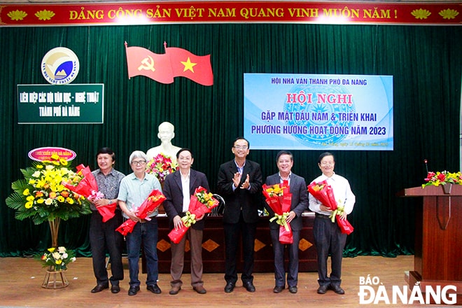 Phó Chủ tịch Liên hiệp các Hội văn học - nghệ thuật thành phố Nguyễn Nho Khiêm (thứ 3, phải qua) tặng hoa chúc mừng các tác giả đoạt giải thưởng văn học nghệ thuật thành phố lần thứ 4 (2015-2020). Ảnh: X.D