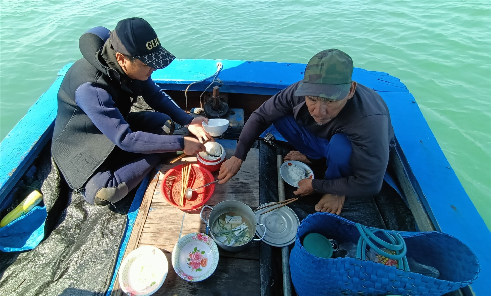 Ngư dân ăn cơm trên thuyền và lấy lại sức để săn tôm hùm nhí. Ảnh: N.Q