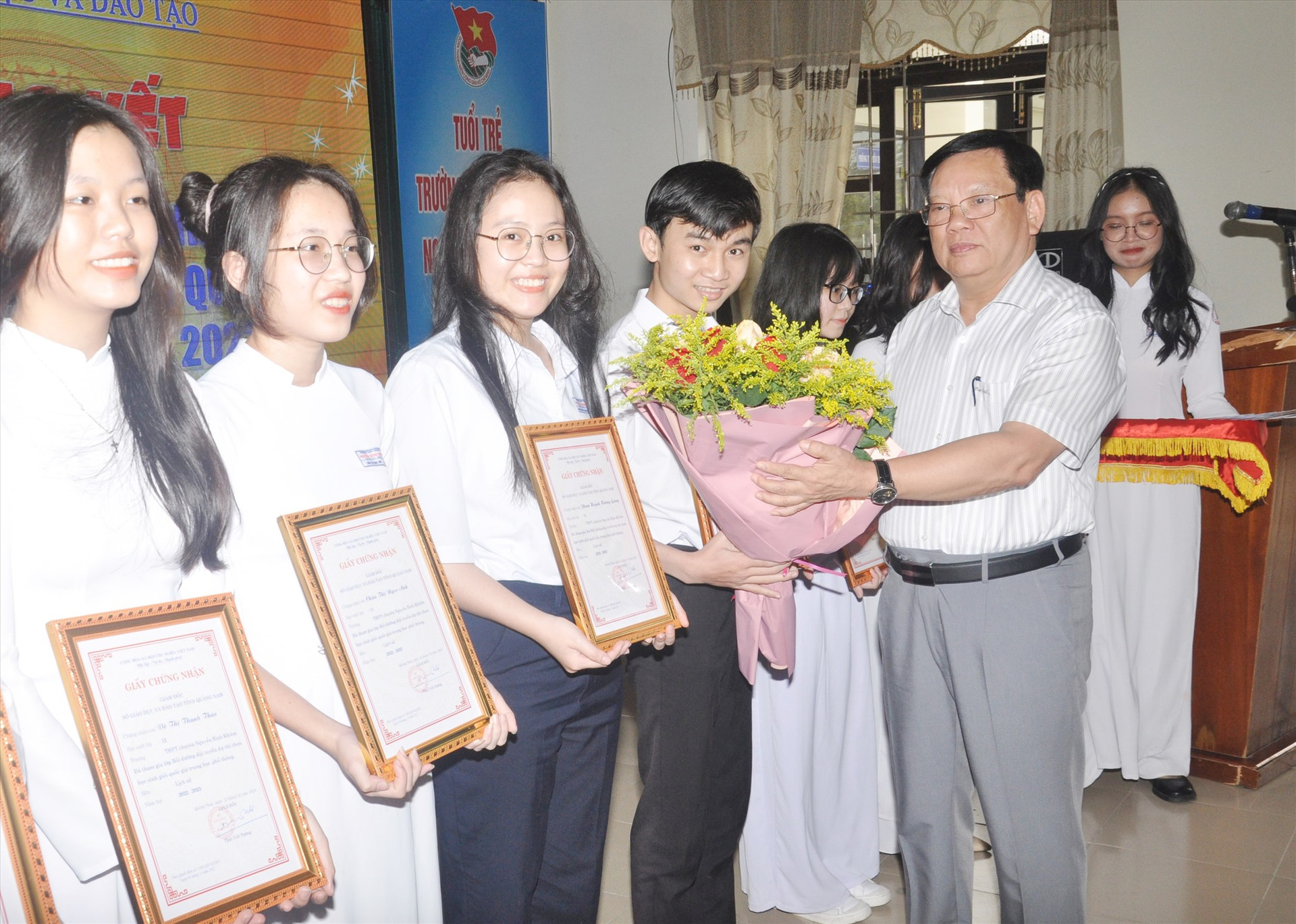 Giám đốc Sở GD-ĐT Thái Viết Tường tặng hoa động viên học sinh thi đạt kết quả tốt. Ảnh: X.P