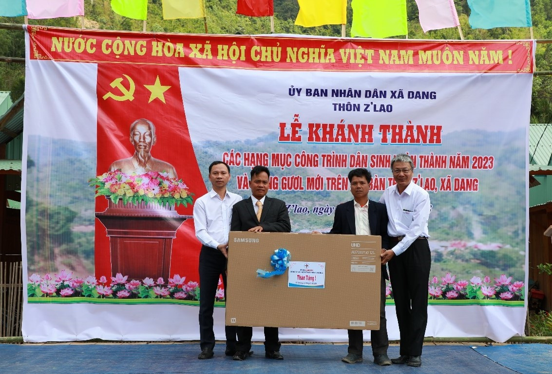 Ông Ngô Xuân Thế - Phó Tổng Giám đốc Công ty CP Thủy điện A Vương (ngoài cùng bên phải) trao tặng ti vi cho bà con thôn Z'lao. Ảnh: V.L