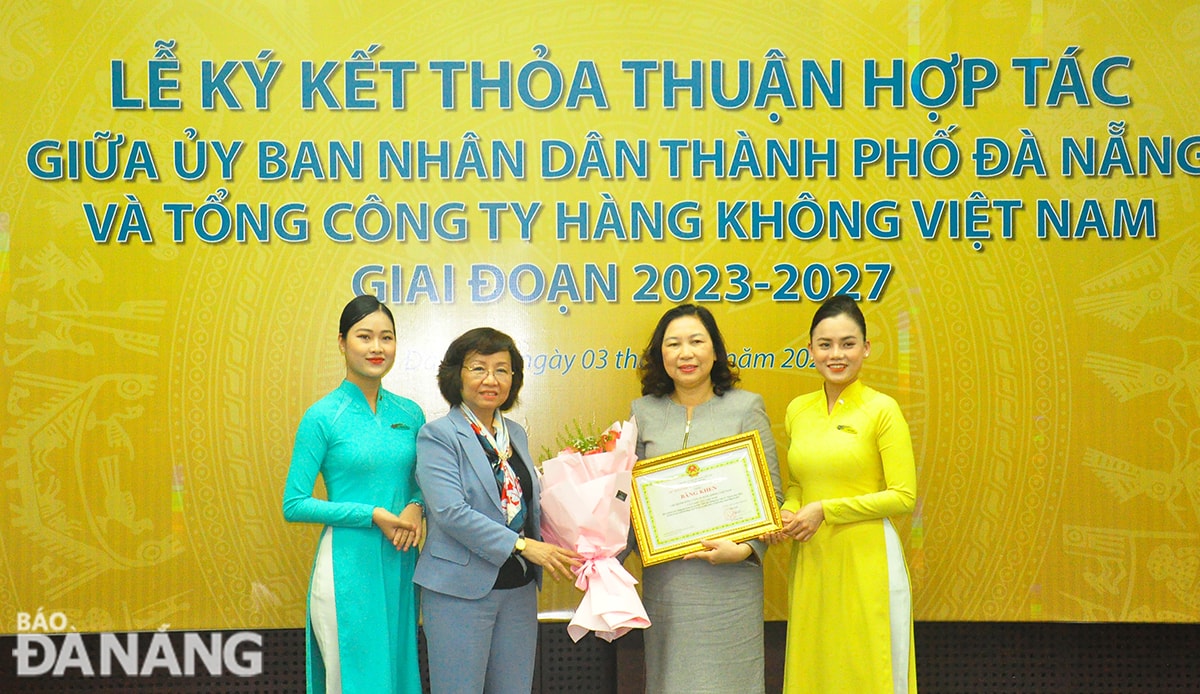 Thừa ủy nhiệm của Chủ tịch UBND thành phố, Phó Chủ tịch UBND thành phố Ngô Thị Kim Yến (thứ 2 từ trái sang), trao Bằng khen cho Chi nhánh Tổng Công ty Hàng không Việt Nam – CTCP Khu vực Việt Nam. Ảnh: THÀNH LÂN