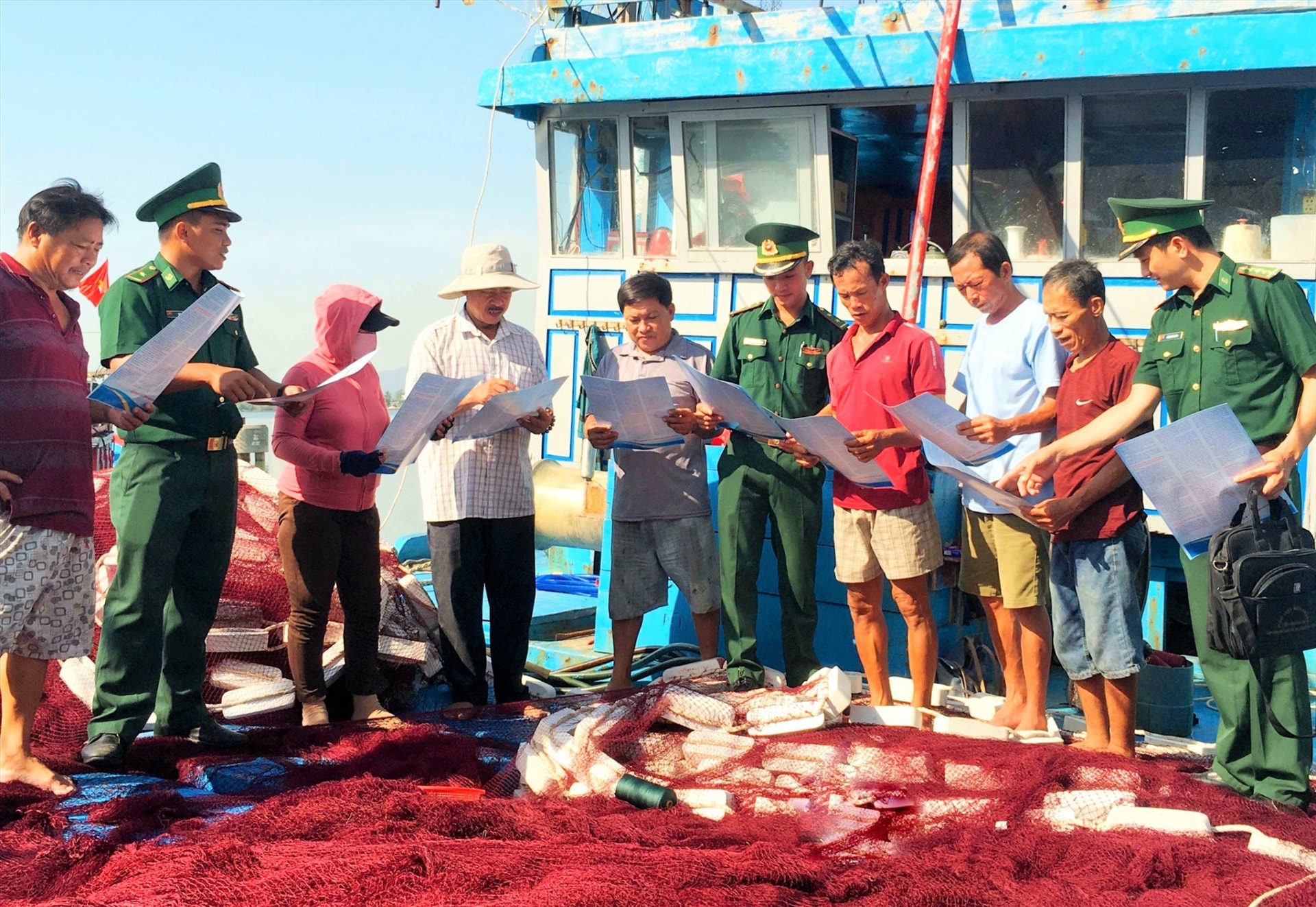 Cán bộ chiến sĩ Đồn Biên phòng cửa khẩu cảng Kỳ Hà (Núi Thành) tuyên truyền ngư dân về Luật biển. Ảnh: ĐĂNG NGUYÊN