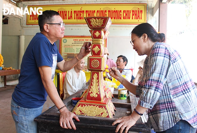 Tổ trang trí gấp rút sơn sửa chân đèn, phục vụ cho lễ hội.
