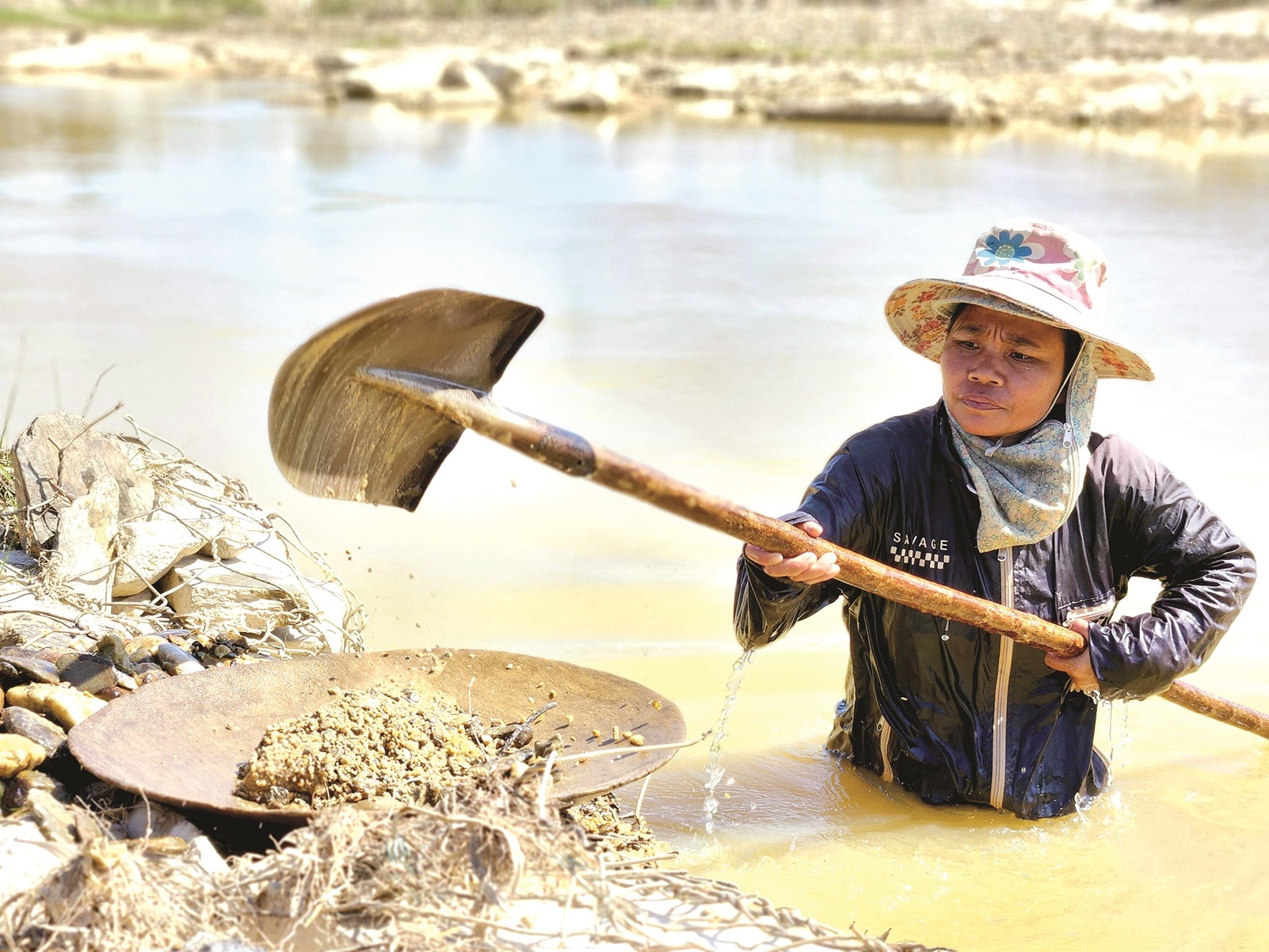 Xúc cát sạn dưới đáy suối để đãi.