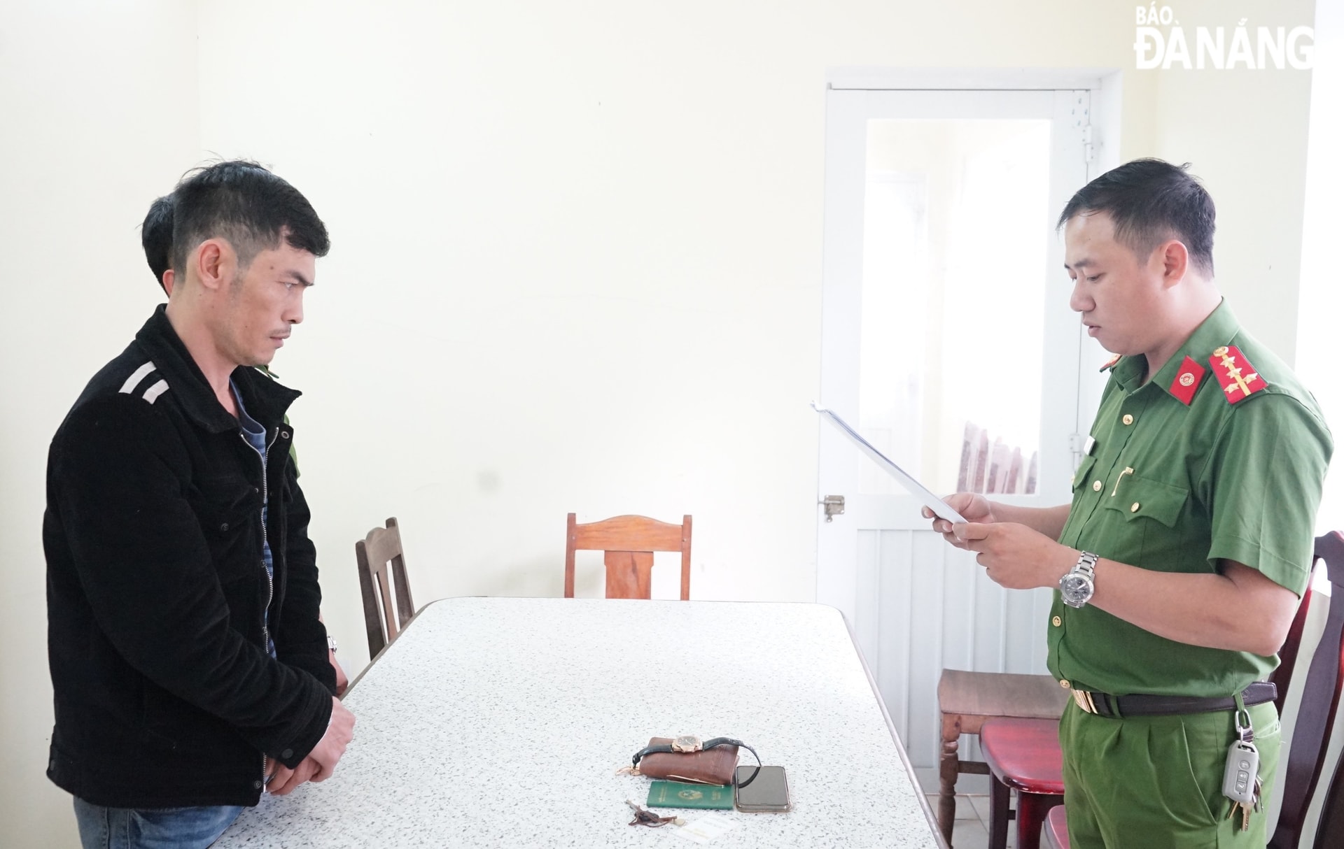 Cơ quan Cảnh sát điều tra, Công an thành phố thực hiện lệnh bắt tạm giam đối tượng Vũ Quốc Khánh (trái). Ảnh: TRÍ DŨNG