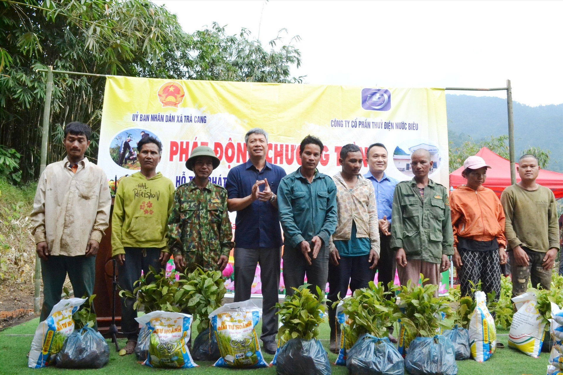 Phó Chủ tịch UBND tỉnh Hồ Quang Bửu và ông Nguyễn Minh Dũng trao gạo và cây giống cho các hộ dân thôn 3 xã Trà Cang. Ảnh: Q.VIỆT