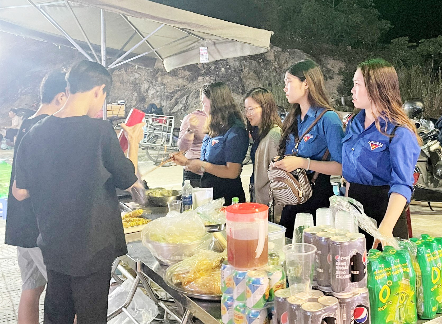 Các cô giáo của Trường Phổ thông dân tộc nội trú THCS Nam Giang đứng bán ẩm thực cho du khách và người dân tại chợ đêm. Ảnh: Đ.N