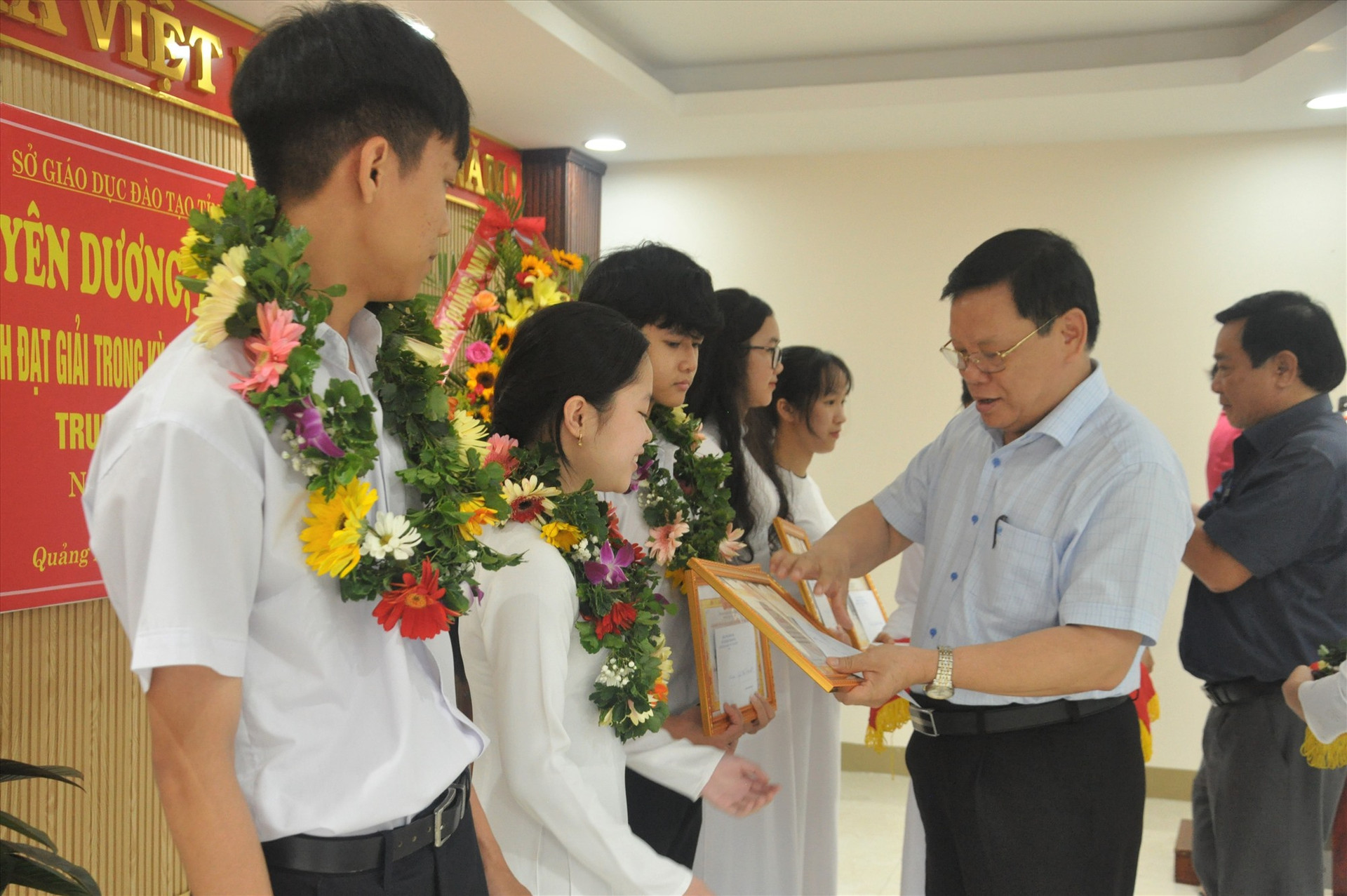Giám đốc Sở GD-ĐT Thái Viết Tường tặng giấy khen và tiền thưởng cho các em đoạt giải. Ảnh: X.P