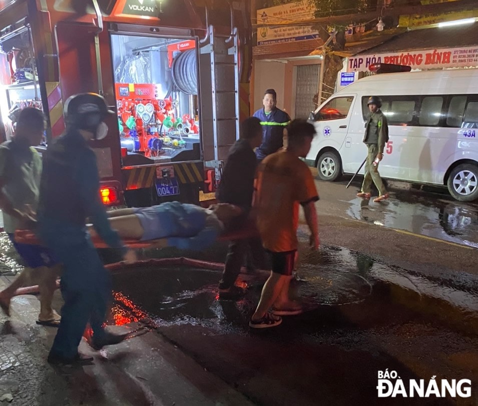 Lực lượng chức năng đưa người bị nạn ra khỏi đám cháy. Ảnh: L.H