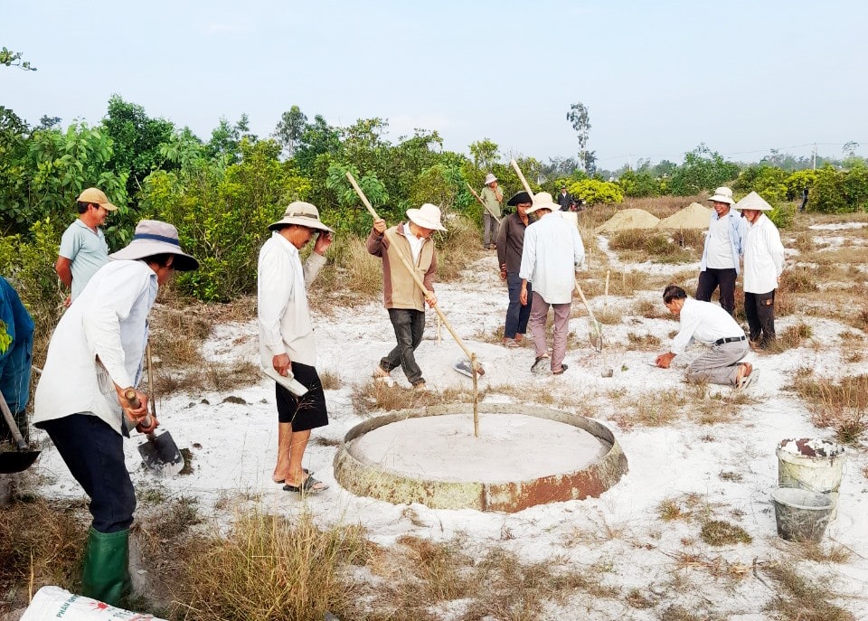 Hàng chục người tham gia xây sửa, chăm sóc những ngôi mộ vô chủ ở làng Tất Viên. Ảnh: C.Q