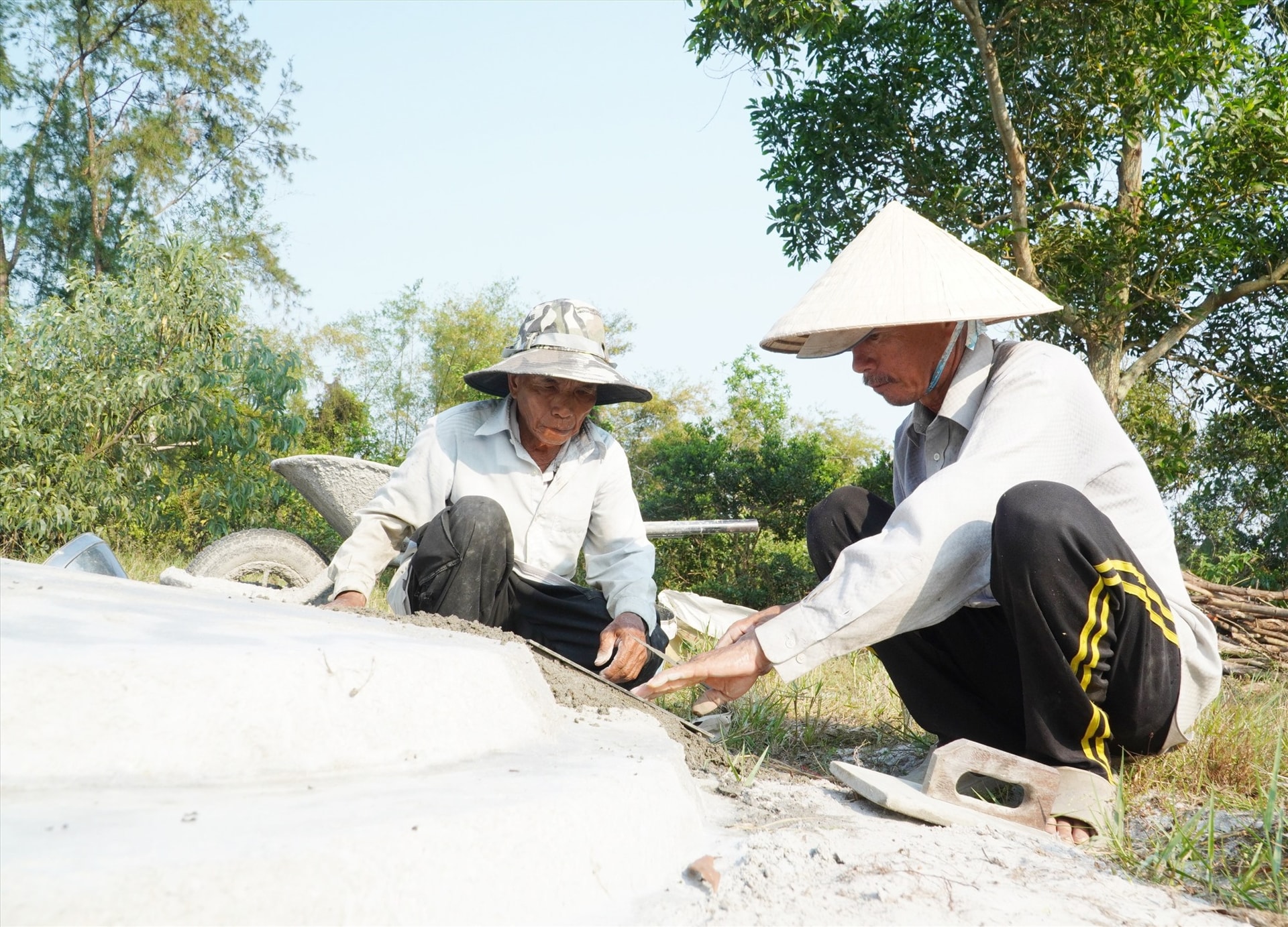 Ông Lập cùng một người trong làng sửa sang mộ thanh minh. Ảnh: C.Q