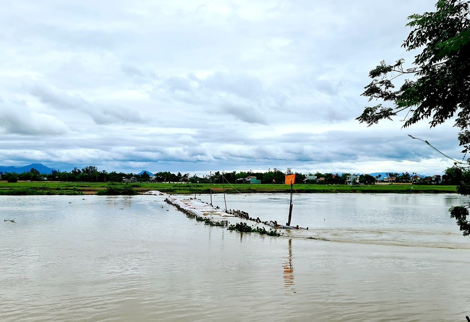 Đập ngăn mặn trên sông Vĩnh Điện bị sạt lở nghiêm trọng trong đợt mưa lũ bất thường xảy ra vào cuối tháng 3 năm 2022. Ảnh: PV