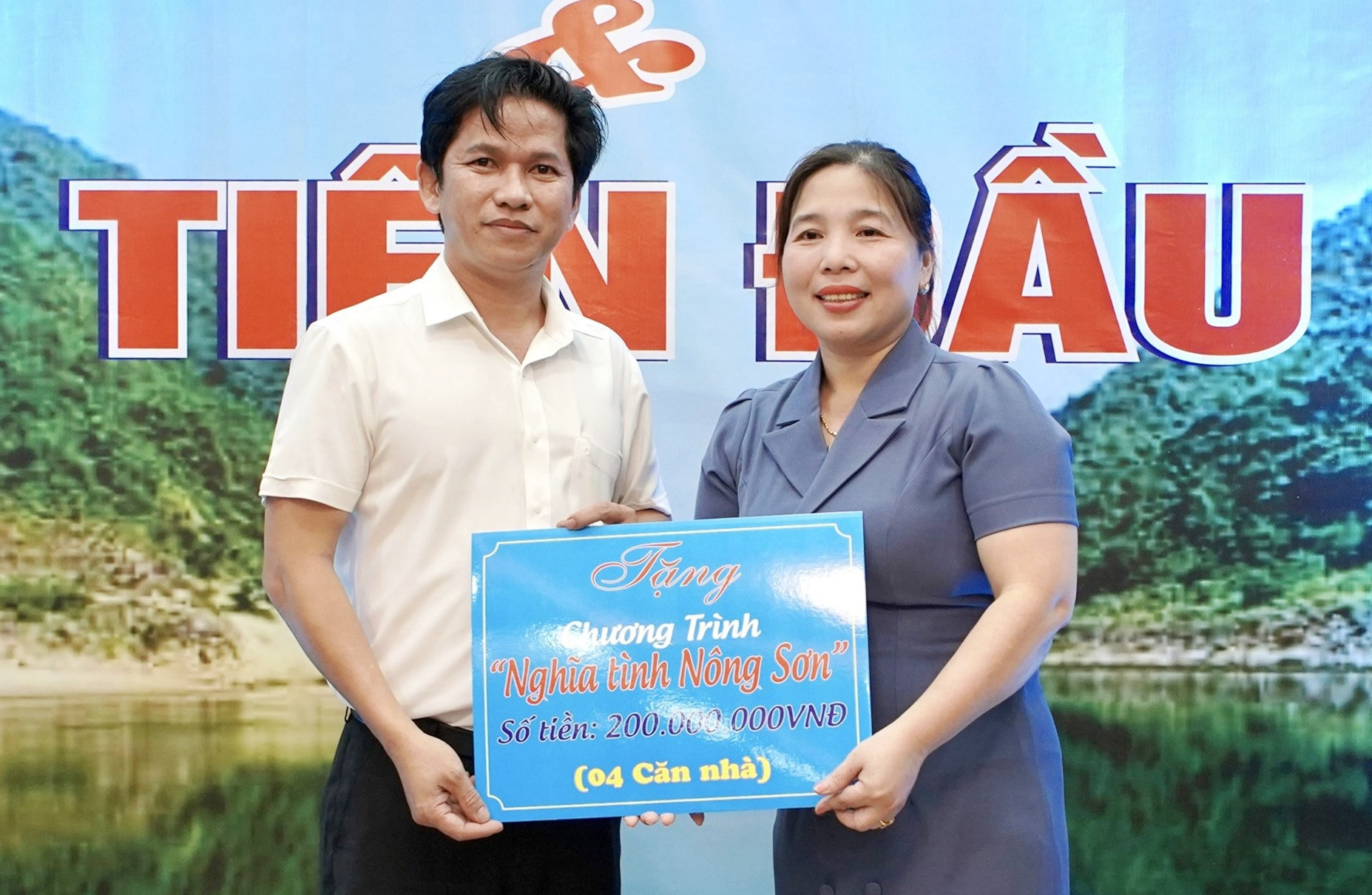 Phó Chủ tịch UBND huyện Nông Sơn - Nguyễn Thị Thu Thủy nhận biểu trưng xóa nhà tạm từ các doanh nghiệp. Ảnh: TÂM LÊ