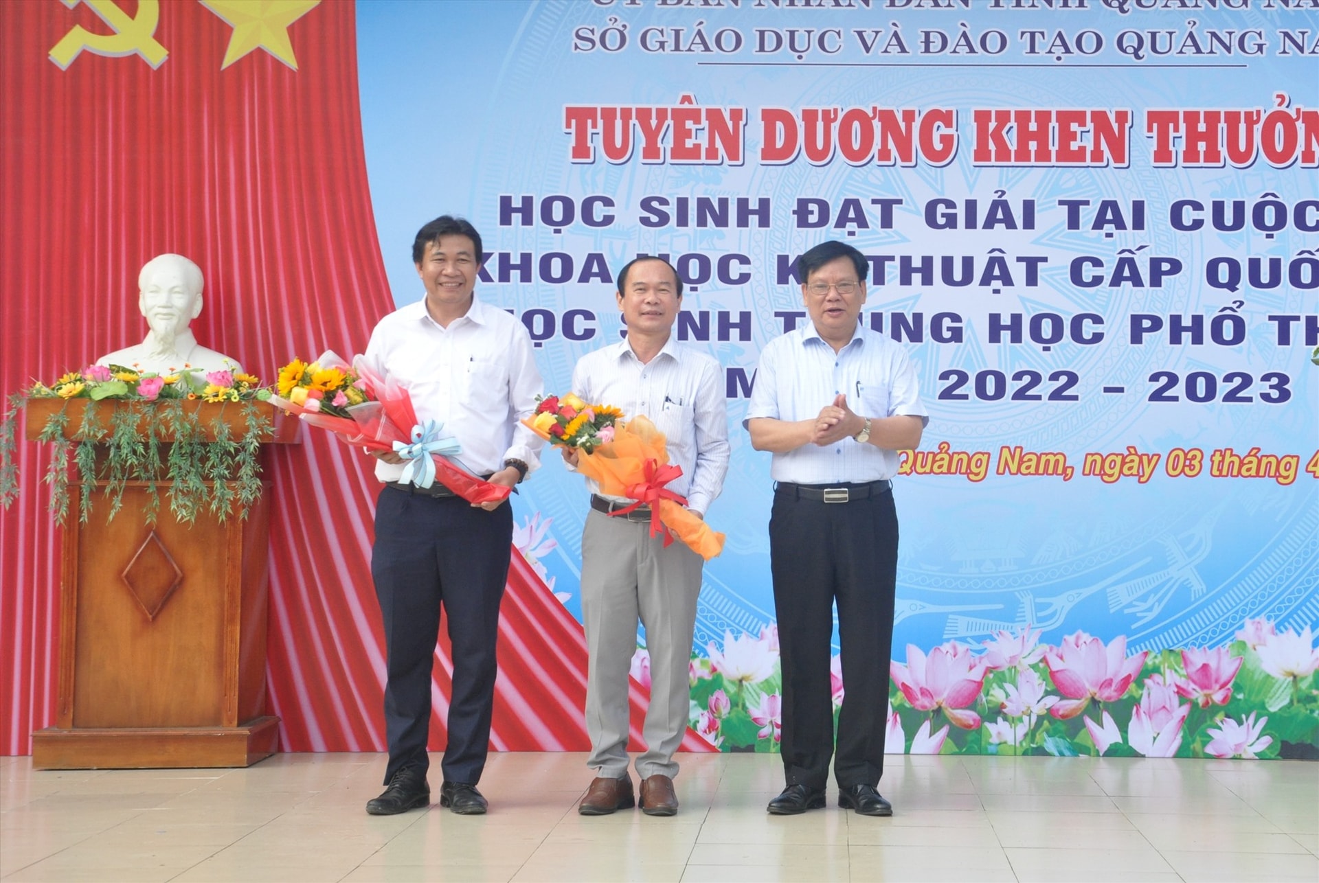 Giám đốc Sở GD-ĐT Thái Viết Tường tặng hoa cho lãnh đạo Trường THPT chuyên Nguyễn Bỉnh Khiêm và giáo viên hướng dẫn. Ảnh: X.P