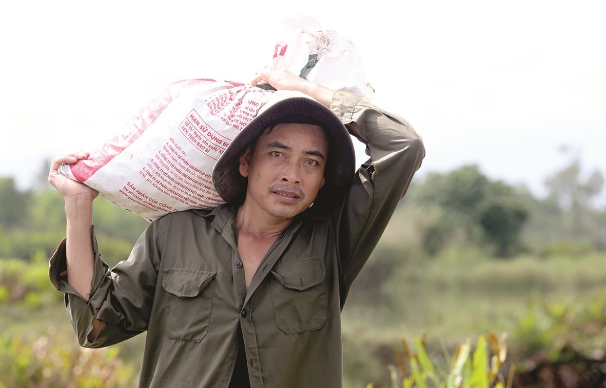 Ông Huỳnh Minh Vỹ vác bao nghêu 30kg đưa về nhà để bán.