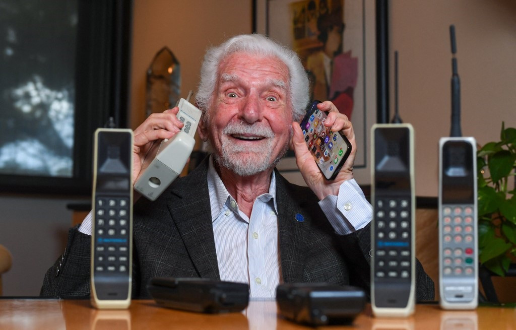 “Cha để” ĐTDĐ Martin Cooper tay phải cầm Motorola DynaTAC 8000X và tay trái cầm điện thoại thông minh hiện nay. Ảnh: Newvision