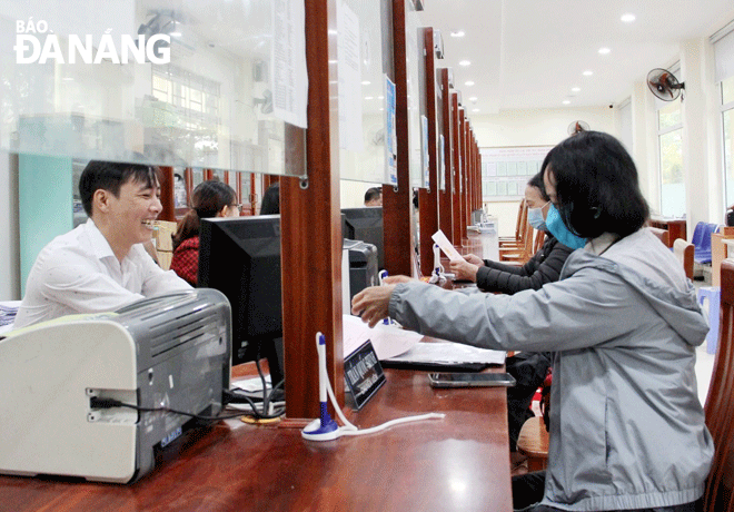 Cán bộ tại bộ phận “Một cửa” quận Ngũ Hành Sơn hướng dẫn người dân, doanh nghiệp nộp thuế. Ảnh: N.QUANG