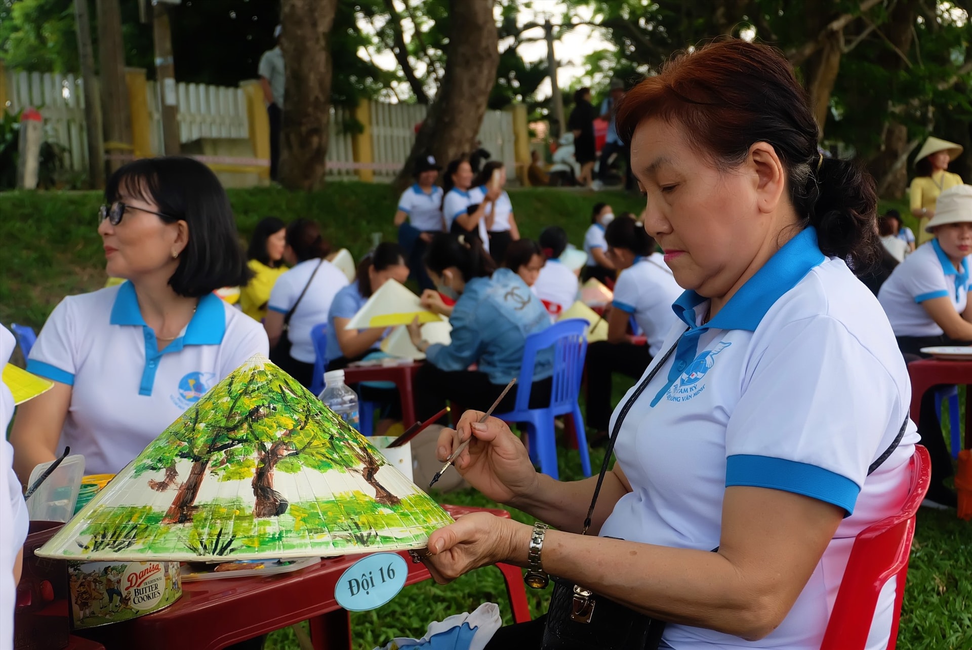 Chị Thanh Nga (phường An Xuân) tỉ mỉ trang trí chiếc nón lá của mình. Ảnh: M.L