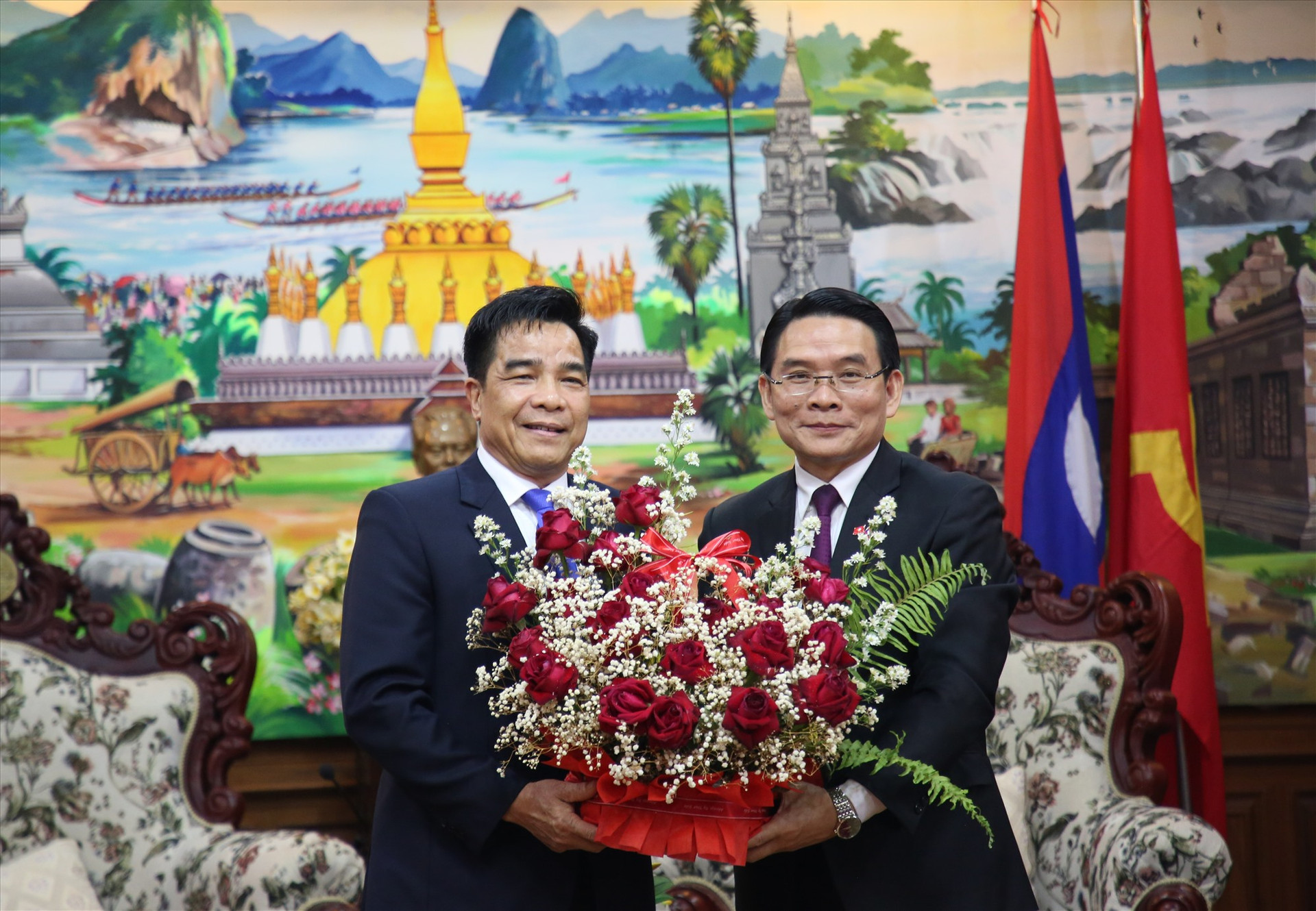 Bí thư, Tỉnh trưởng Chămpask Vi-lay-vông Bút-đa-khăm (bên phải) tặng hoa chào mừng đoàn đại biểu cấp cao Quảng Nam sang thăm, chúc Tết cổ truyền Bunpiamay. Ảnh: Đ.N