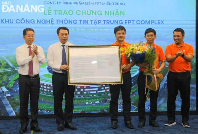 Thứ trưởng Bộ Thông tin và Truyền thông Nguyễn Huy Dũng và Bí thư Thành ủy Nguyễn Văn Quảng trao chứng nhận quyết định cho đại diện Tập đoàn FPT. Ảnh: M.Q