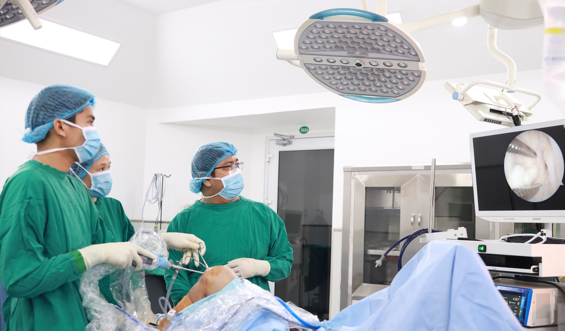Các BS Bệnh viện Đa khoa Gia Đình đang thực hiện phẫu thuật lấy ra hơn 100 viên sỏi trong khớp gối bệnh nhân