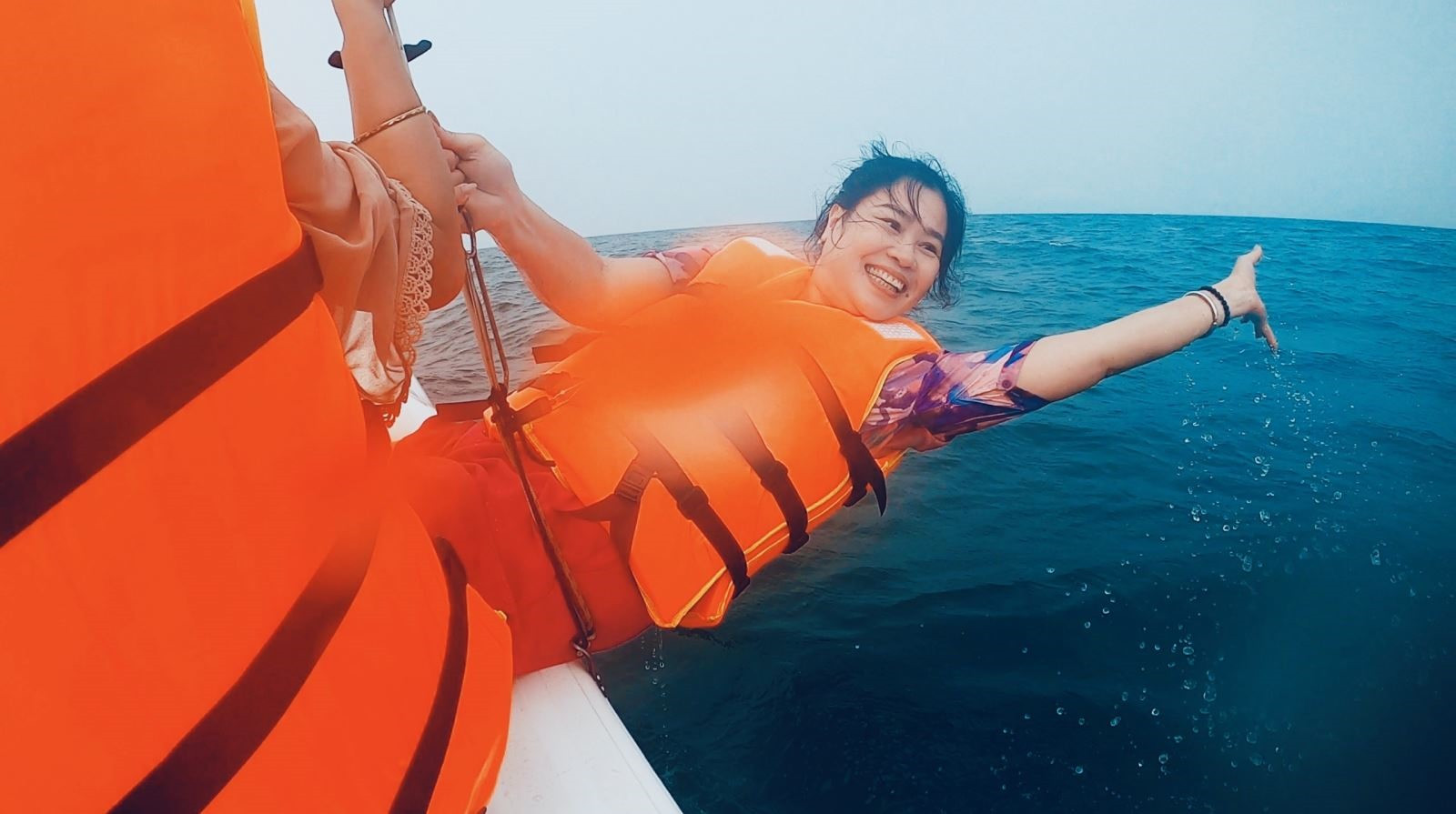 Catamaran players can enjoy the coolness of Cua Dai water by swinging themselves out of the boat.