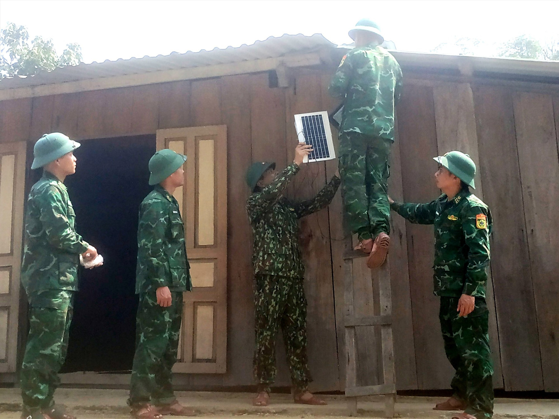 Cán bộ, chiến sĩ Đồn Biên phòng Đắc Pring hỗ trợ người dân lắp đặt đèn năng lượng mặt trời.