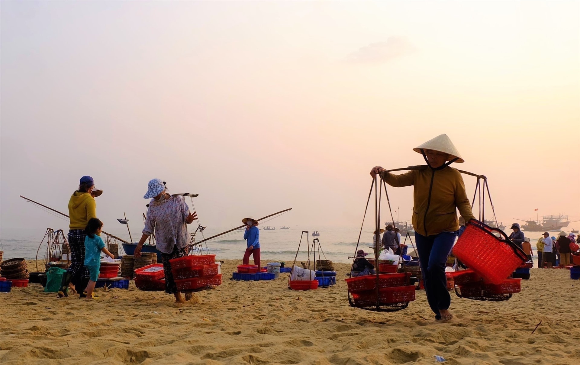 Từ sáng sớm, những nữ phu cá đã thoăn thoắt đôi chân của mình trên cát biển. Ảnh: B.T