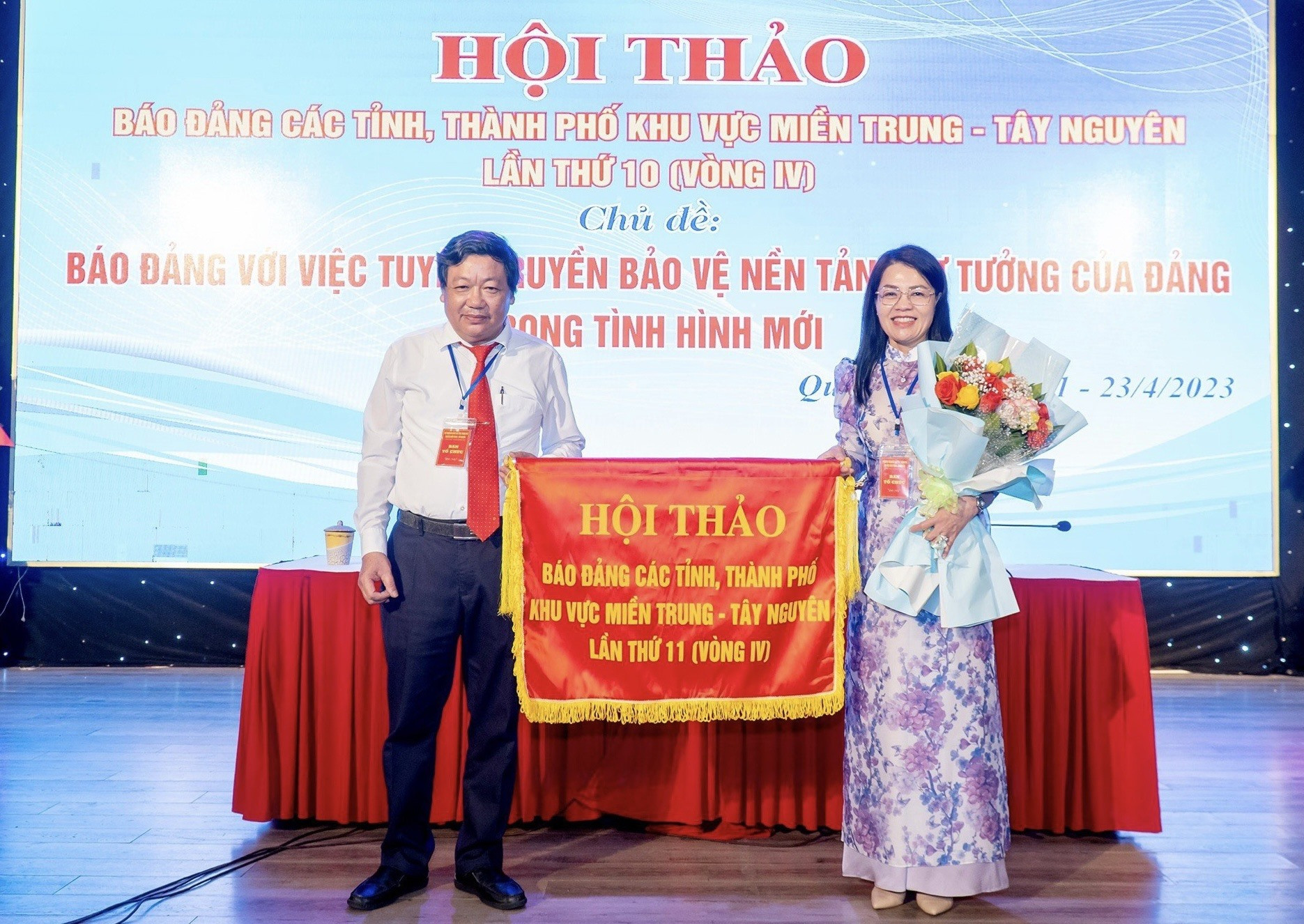 Nhà báo Trương Đức Minh Tứ - Tổng Biên tập Báo Quảng Trị trao cờ đăng cai hội thảo lần sau cho đại diện Báo Lâm Đồng. Ảnh: X.A