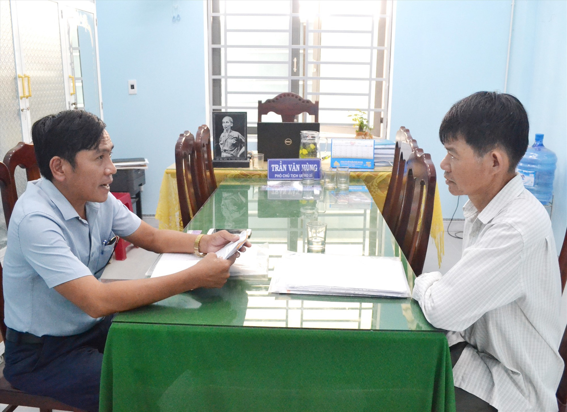 Ông Trần Văn Hùng (bìa trái) trao đổi với ông Mai Văn Ba về vụ án phá rừng tại Bình Lãnh. Ảnh: NGUYỄN QUANG