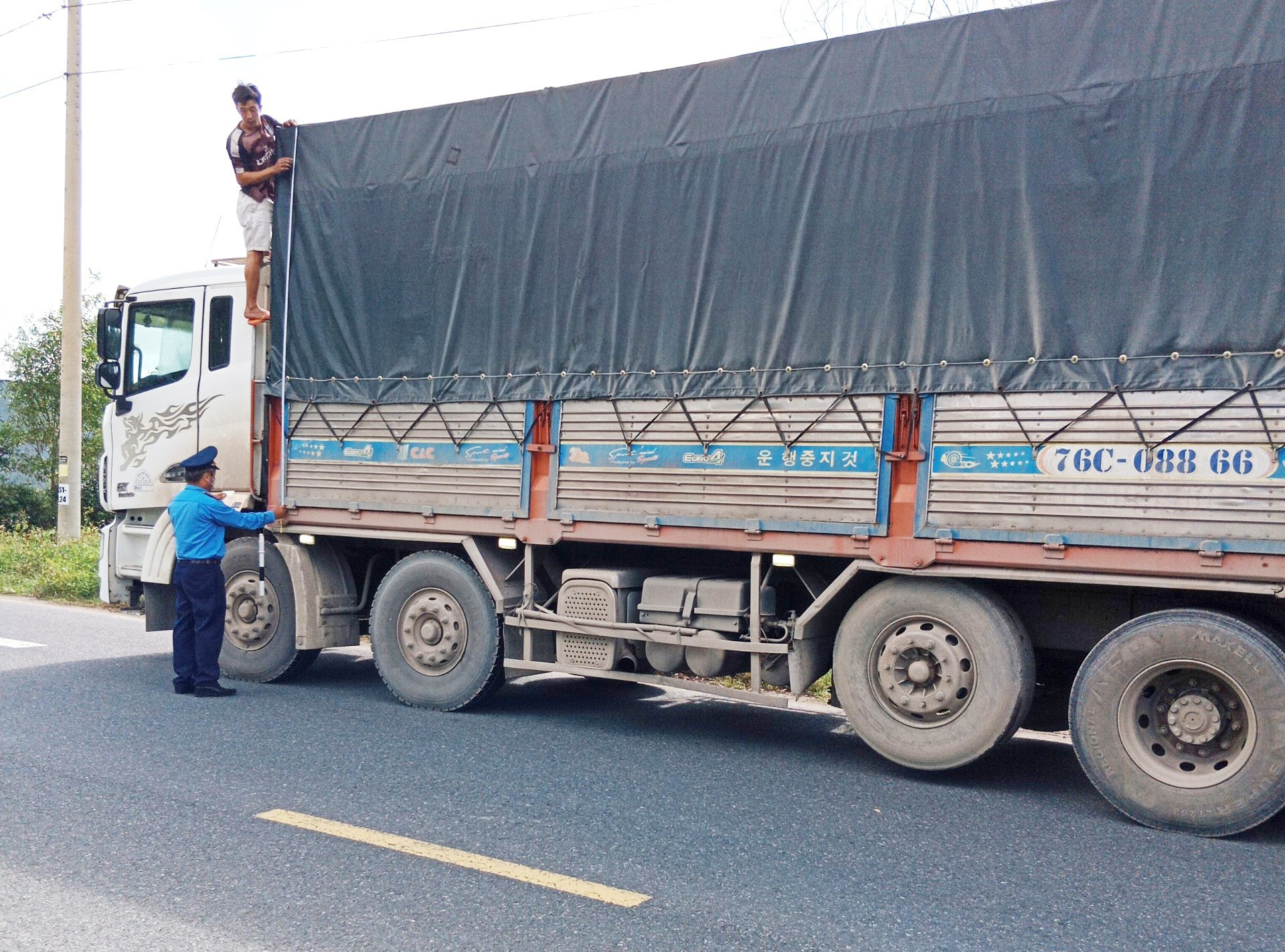 Thanh tra Sở GTVT kiểm soát xe chở hàng hóa trên quốc lộ 14E qua Thăng Bình. Ảnh: SC
