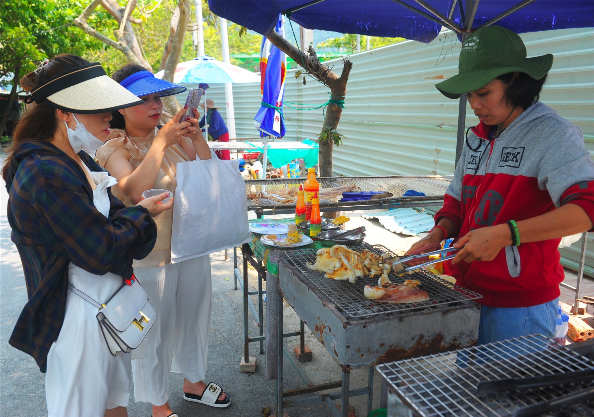 Du khách thích thú với món mực một nắng Cù Lao Chàm,. Ảnh: Minh Quân