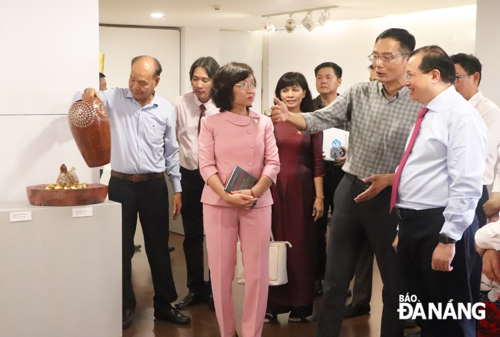 Thứ trưởng Bộ Văn hóa, Thể thao và Du lịch Tạ Quang Đông (bìa phải) tham quan triển lãm “Sản phẩm sơn mài Việt Nam” tổ chức tại Đà Nẵng. Ảnh: X.D